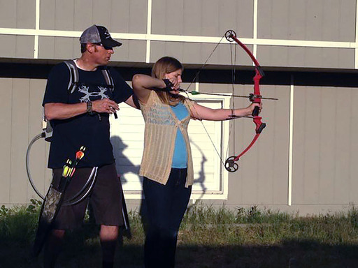 Kelsey Shepherd, 13, gets archery pointers from Dad. Randys wearing the Freedom portable driver in the backpack that powers the SynCardia Total Artificial Heart.