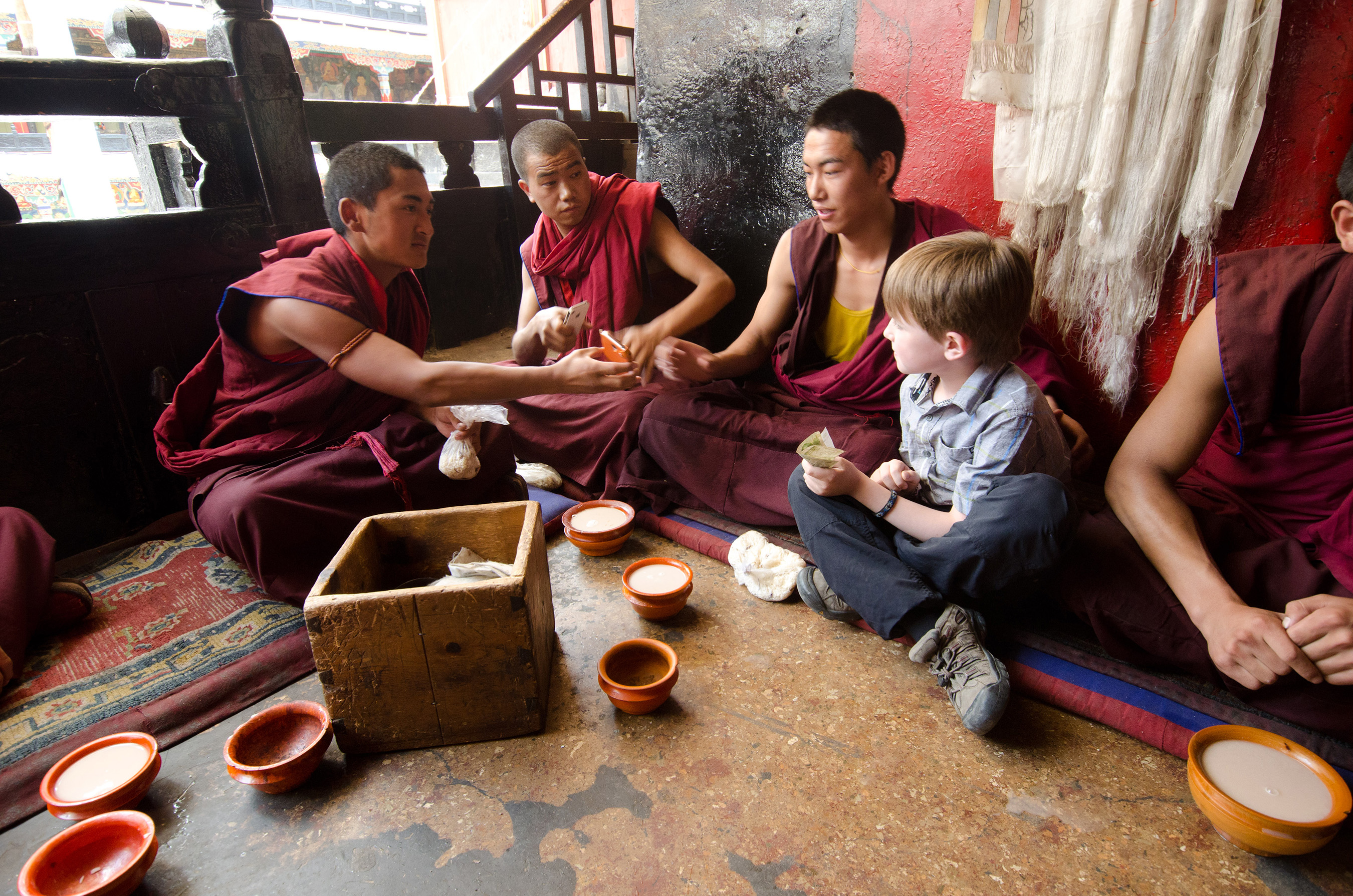 Bodi sits down with local Tibetan Monks in Lhasa to make an offering. They couldn't resist taking a few photos with their new friend! (Leg 4)