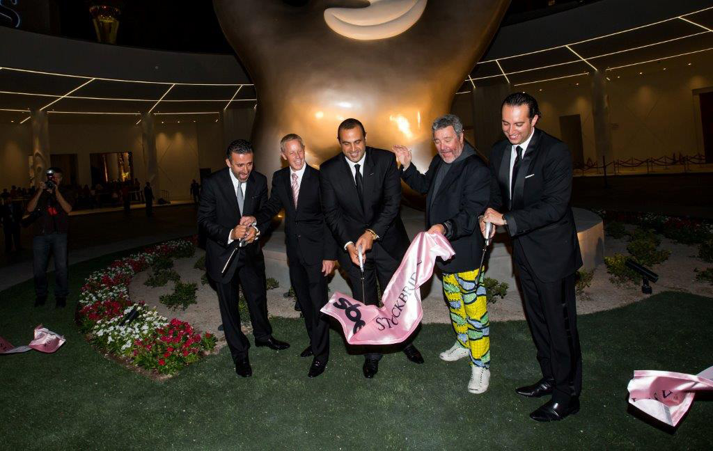 SLS Las Vegas executives, led by sbe Chairman and CEO Sam Nazarian, center, cut the ceremonial ribbon officially opening the new $415 million resort casino at the stroke of midnight on Saturday.