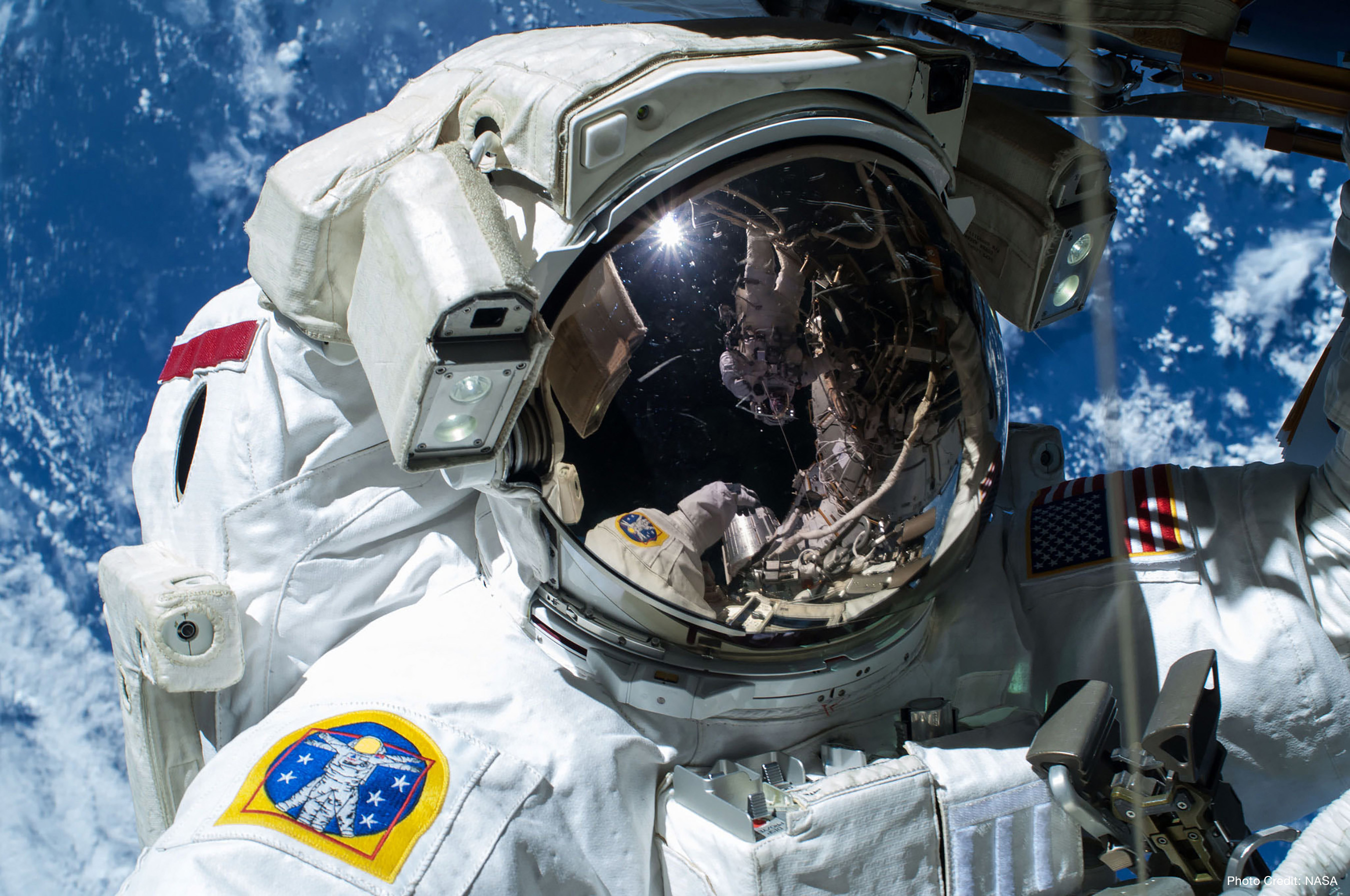 NASA astronaut Barry "Butch" Wilmore, Commander of Expedition 42 is caught by the camera during a spacewalk on Feb. 21, 2015, as the Earth's surface passes by in the background. Photo credit: NASA.