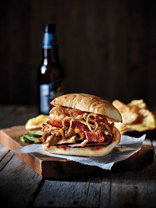 Stacked high with pulled pork, Black Forest ham, thick-sliced bacon, crispy onions and melted cheddar cheese on a Ciabatta bun, the Triple Hog Dare Ya is an elevated bar-and-grill classic.
