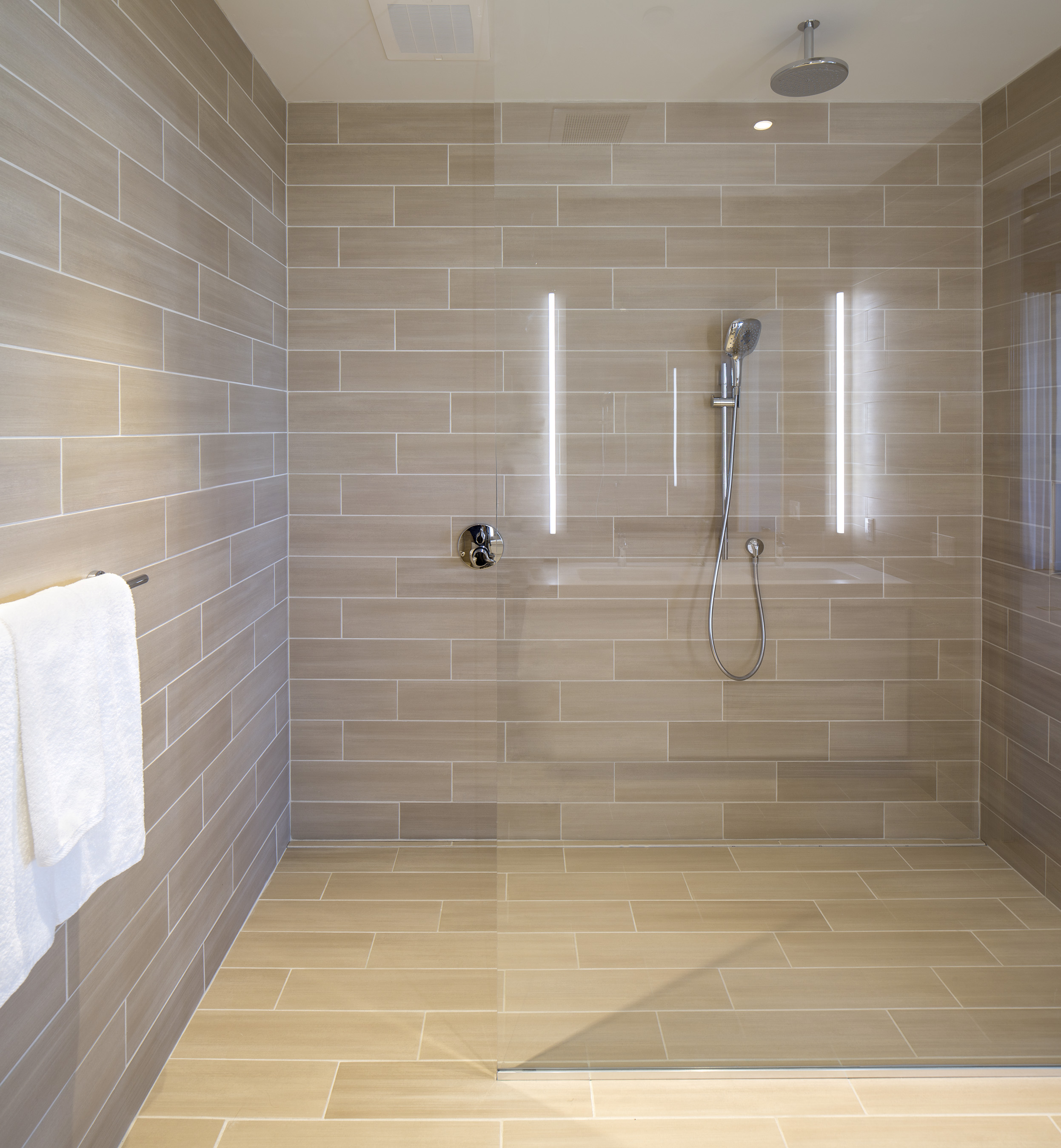 The modern bathroom offers a luxurious, open-design shower with rainfall shower head that delivers a truly spa-like experience.