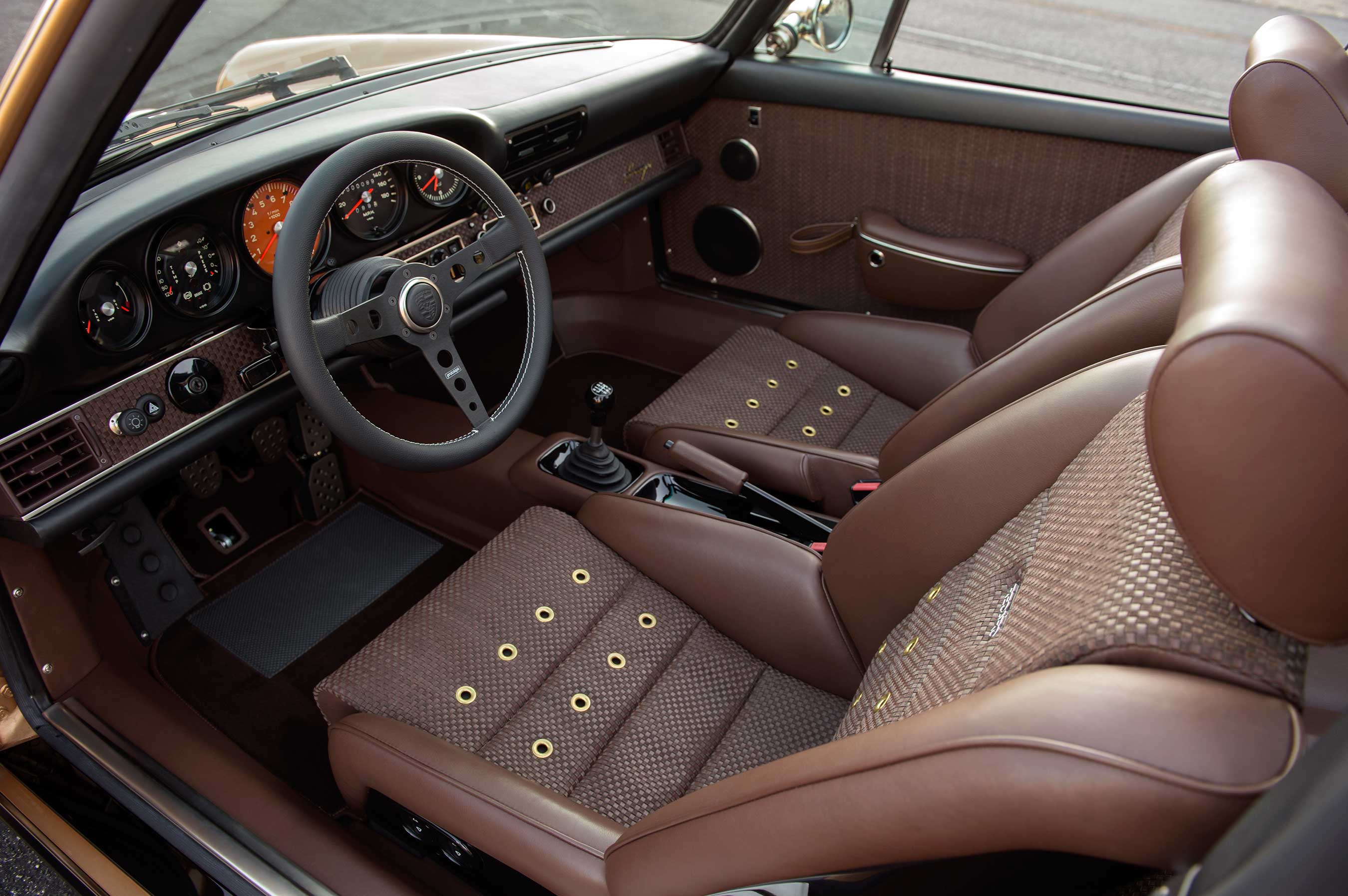 Interior modifications by Singer Vehicle Design for this customers’ Targa include ‘Tobacco Brown’ woven leather and suede weave with grommets on front sports seats and folding rear seats, suggesting a “touring” style.