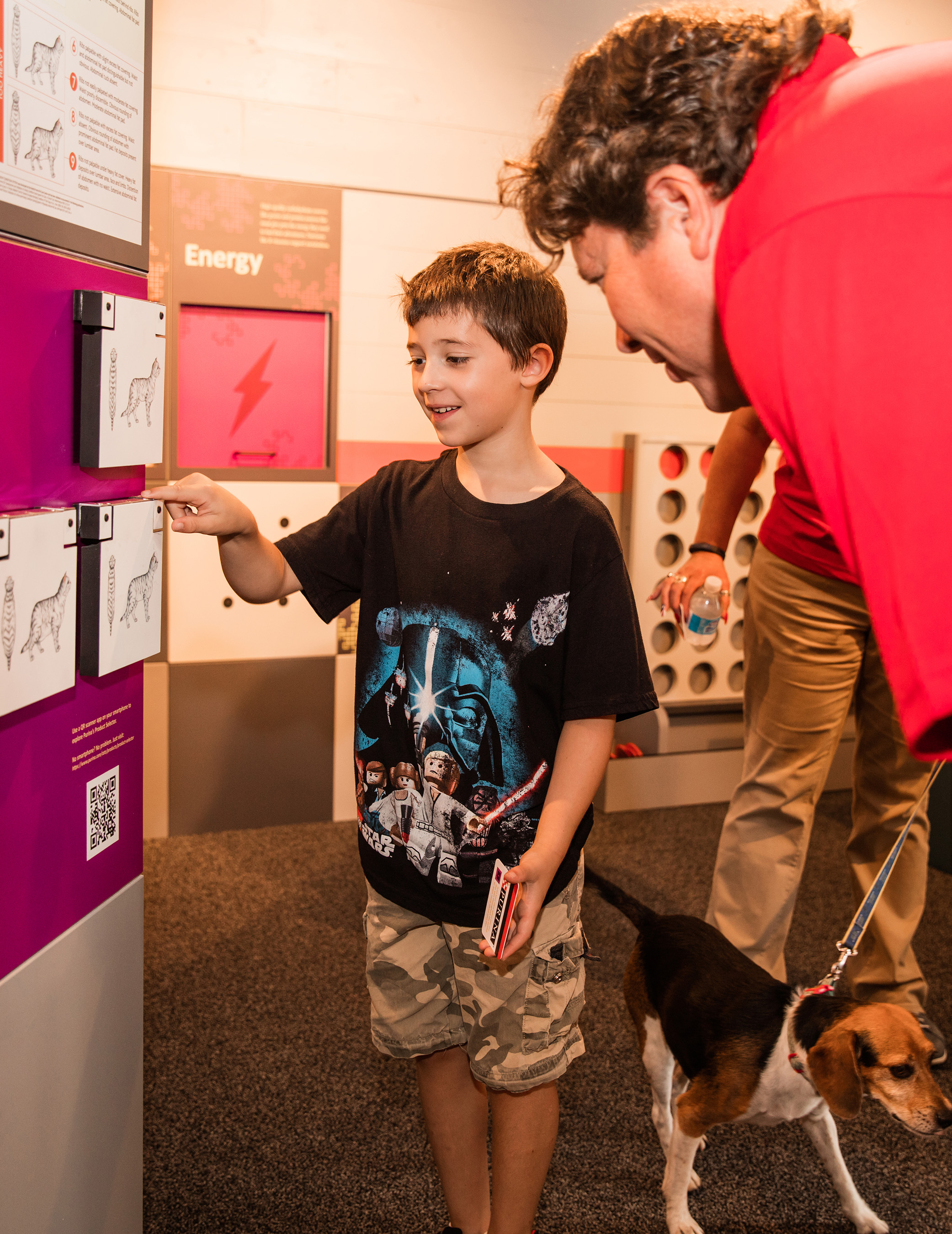 Ben Hiatt, 8, learns about feeding instructions to nourish dogs and cats to their ideal body condition with Dr. Kurt Venator, a Purina veterinarian, during the July 14, 2016, grand opening of “Better with Pets,” a new exhibit at the Purina Farms Visitor Center in Gray Summit, Missouri.