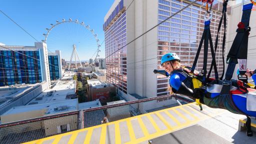 A woman poses in super-hero fashion at the start of the Zipline.