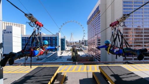 Two people taking off at the start of the zipline.