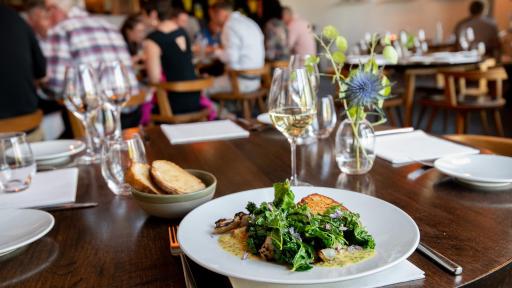 Glass of white wine and plate with greens