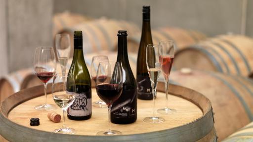 Bottles and glasses of wine on a wooden barrel