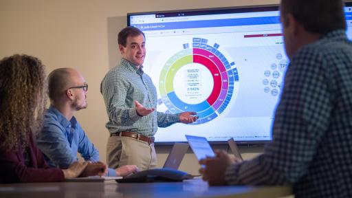 Man in front of a group discussing the St. Jude Cloud interface, which is showing on a large screen.