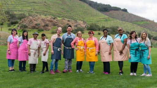 Men and women, the contestants, standing side-by-side in a field.