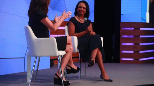 Michele Tafoya and Dr. Condoleezza Rice sitting on a stage in chairs talking.