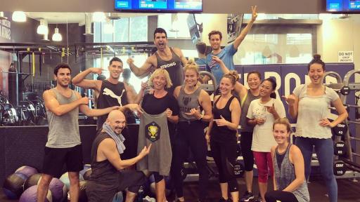 Group of people celebrating 100th workout.