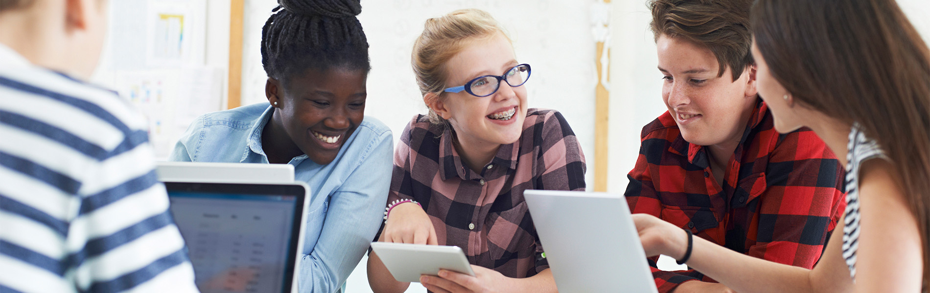 Children gathered around a table sharing information.