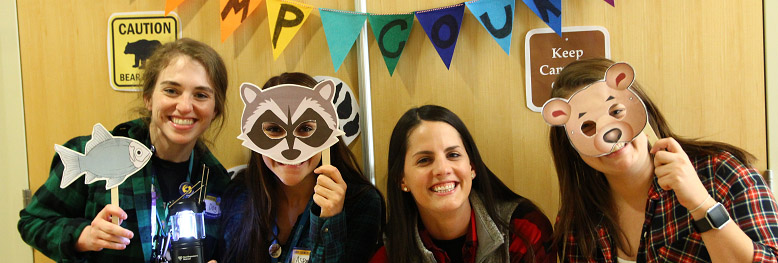 Four girls holding animal masks and signs