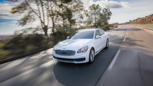 Exterior view of the car on a highway in the sunlight and trees in the background.
