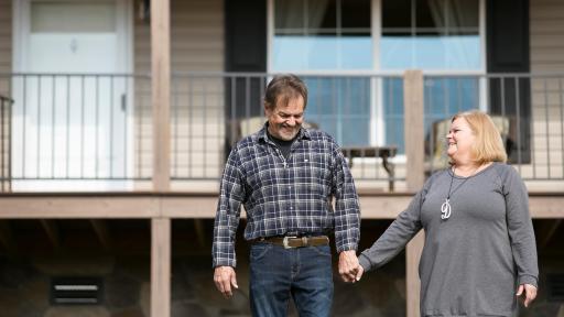The Wood couple standing in front of home