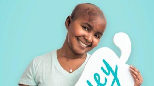 Child holding a cardboard pepper with her name on it - Marley