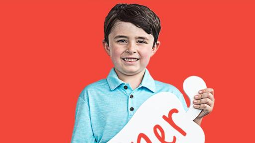 Child holding a cardboard pepper with his name on it - Warner