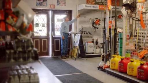 An older man turns on a light as he opens his shop.