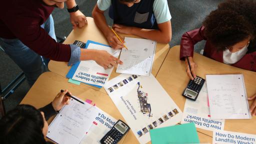 People doing work on paper and calculators