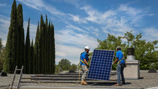 Two SunPower techs installing solar panels on a roof