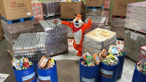Tony the Tiger surrounded by donated food collected for food drive