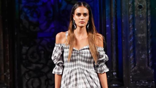 Female model walking down the runway wearing a grey and white checkered print cotton dress