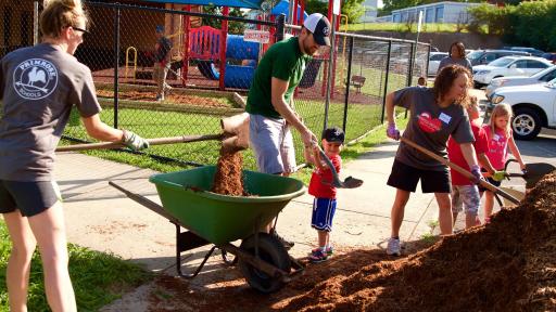 Group of people shoveling mulch