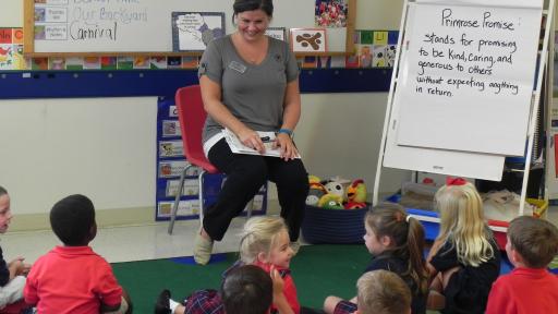 Woman talking to a group of seated children