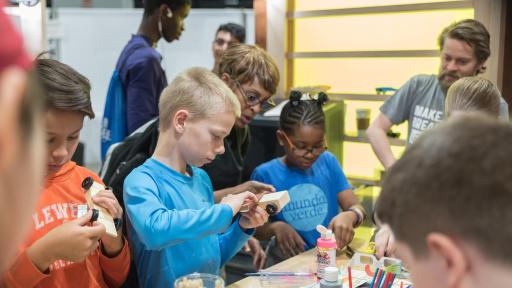 Children working on wooden toy race cars