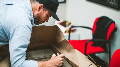 Brian Steorts leaning in and marking a surface with a black marker.
