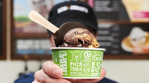A Ben & Jerry's employee holds three waffle cones, each with a scoop of the new ice creams.
