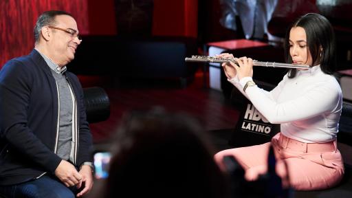 Gilberto Santa Rosa watching woman play flute