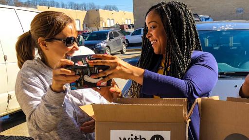 Amber Akisanya, U by Kotex brand manager, sorts U by Kotex product with volunteer. U by Kotex is launching With U, She Can because a period should never stand in the way of a women&rsquo;s progress.