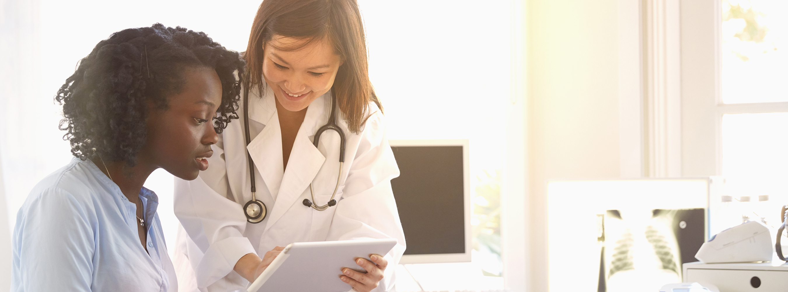 Doctor in a lab coat reviewing information with a patient