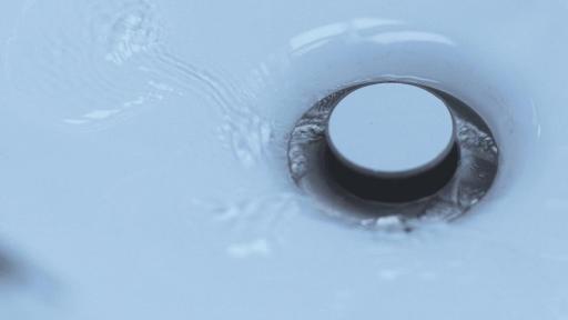 Water going down drain revealing the words turn off the faucet