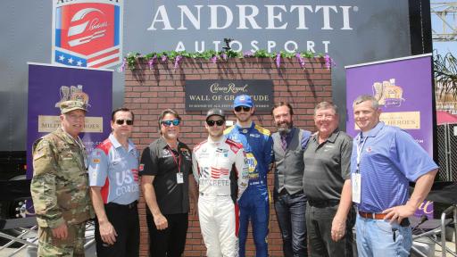 8 men in front of Wall of Gratitude by Crown Royal and Andretti AutoSport