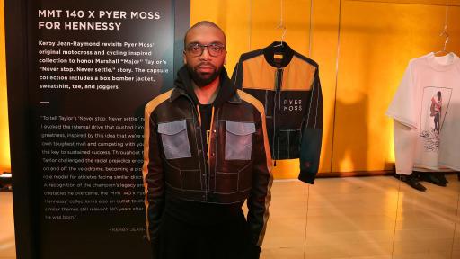 A fashionable man wearing a cycling-inspired hat and coat collection by designer Kerby Jean-Reymond