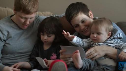 Two married women sitting with their children in their arms.