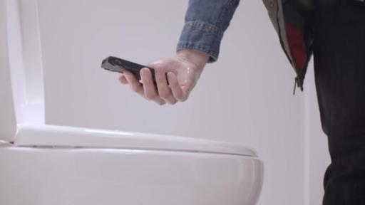 Man fishing his hand out of a white Niagra toilet.