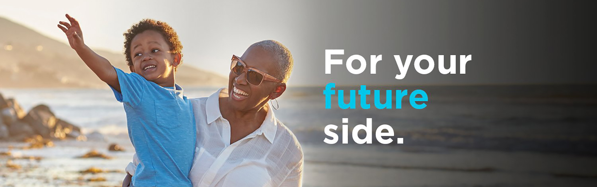 An elderly woman holding a child on the beach
