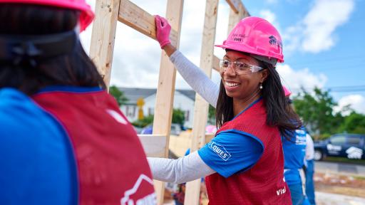 Women putting up frame of house