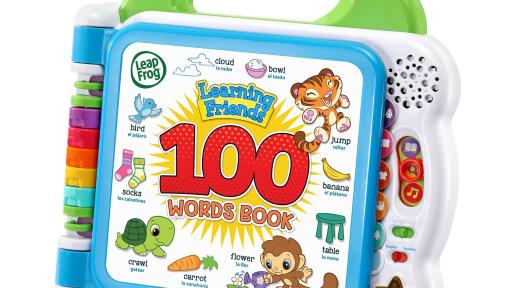 Girl sitting in living room playing with Leap Frog Learning Friends 100 Words Book