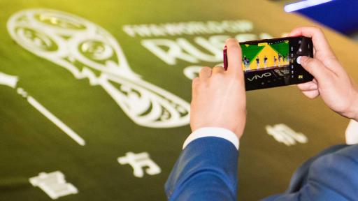 A Vivo Super Fan Photographer taking a picture of the launch event with a Vivo smartphone