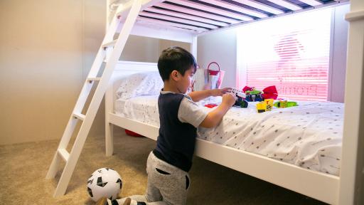 Boy playing with toys atop bed