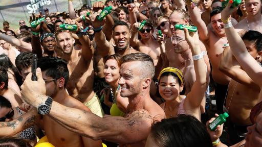 Man in crowd taking a selfie.