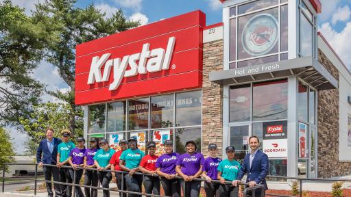 Several employees standing outside a Krystal restaurant