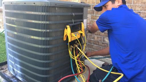 An installation technician from Fresh Air, Inc., in Houston installs a new Carrier air conditioner at a Habitat for Humanity home.