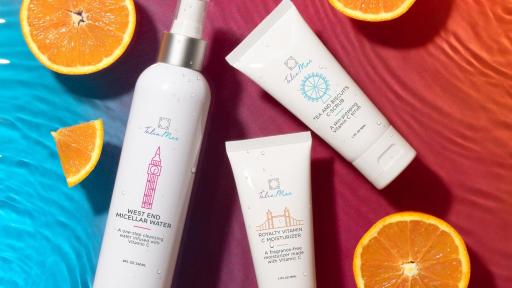 Cosmetics on gradient background with orange slices and water ripples