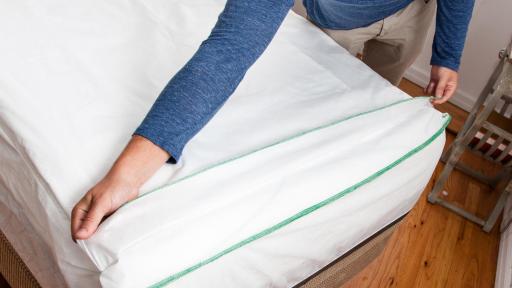 Man peeling a sheet away from a twin sized matrice.